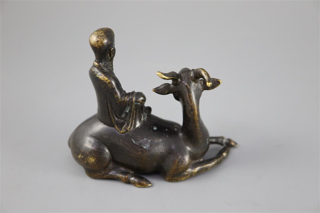 A Chinese late Ming bronze group of an immortal seated on a recumbent deer, 12.5cm long